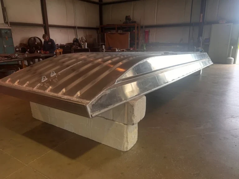 Underside of a bare aluminum hull on stands