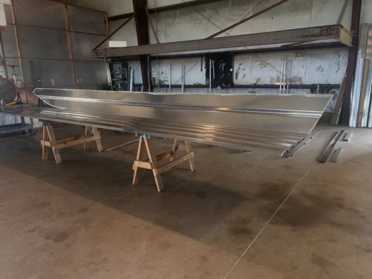 Bare aluminum hull on sawhorses in the shop