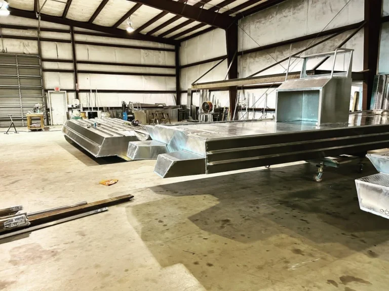 Two bare aluminum hulls side by side in the shop