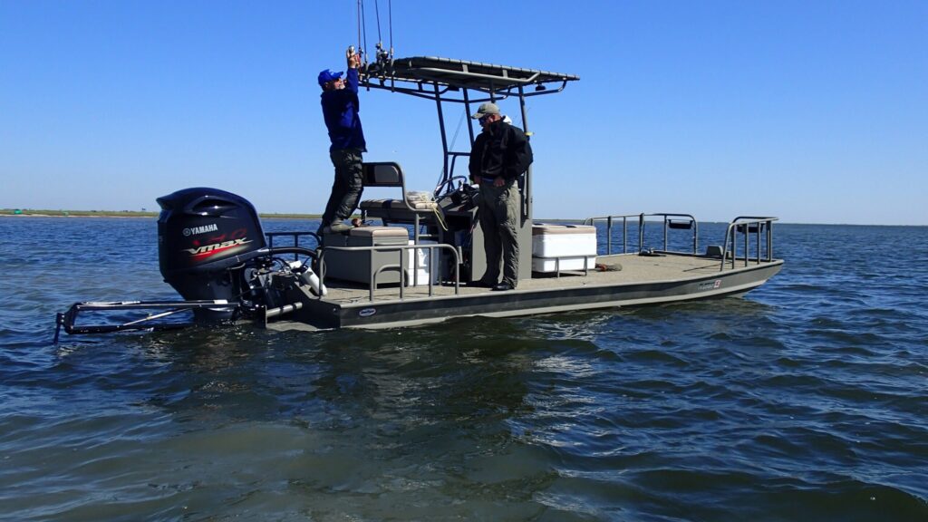 Two men aboard a Boat Right Big Shell on open bay water