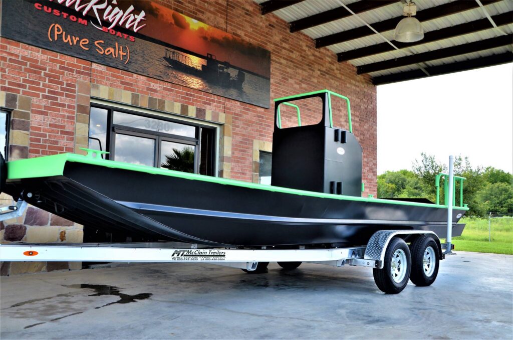 Black and green Boat Right High Tide on its trailer outside the shop