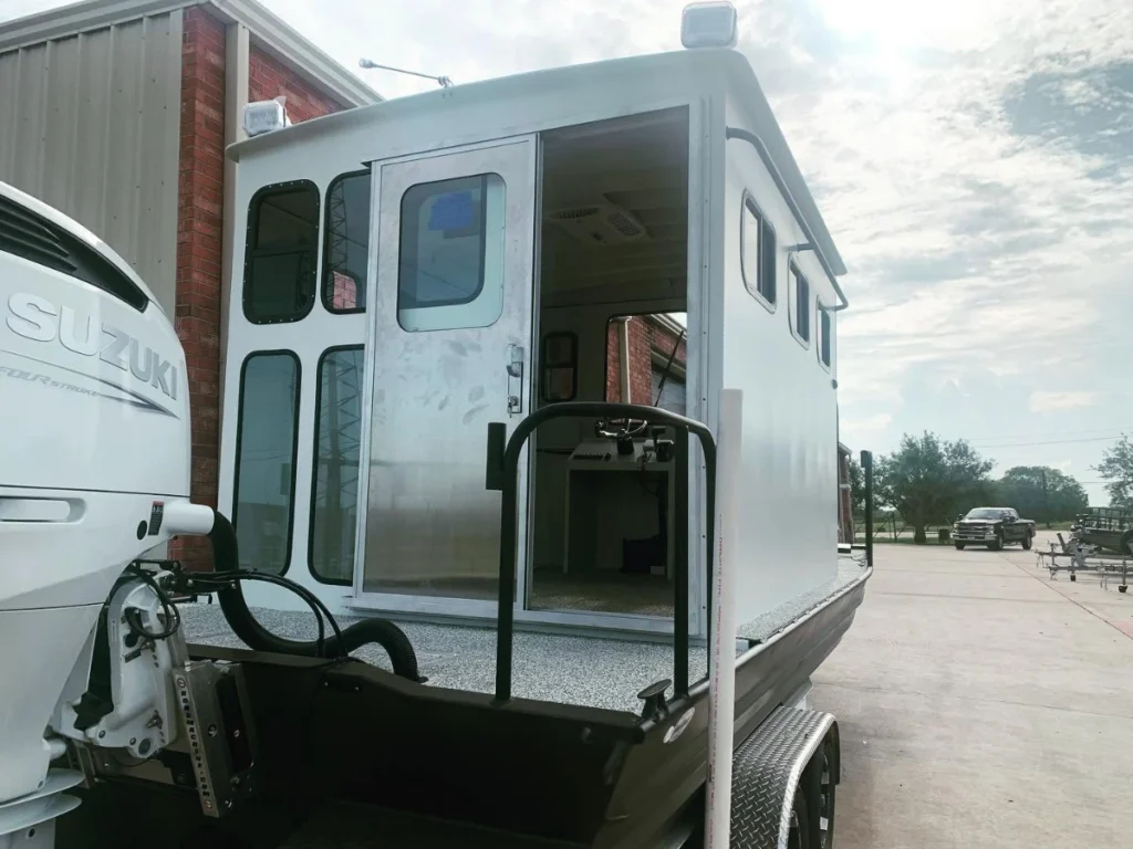 Aluminum cabin boat on its trailer, seen from the stern quarter