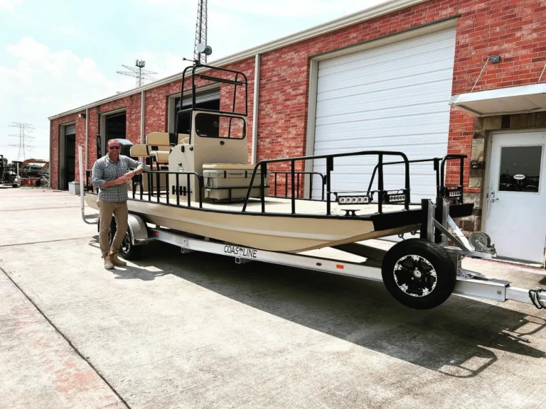 Owner beside his tan Boat Right outside the shop doors