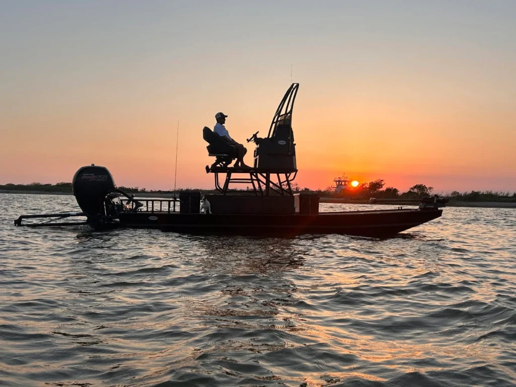 Angler seated on the tower of a Boat Right at sunset