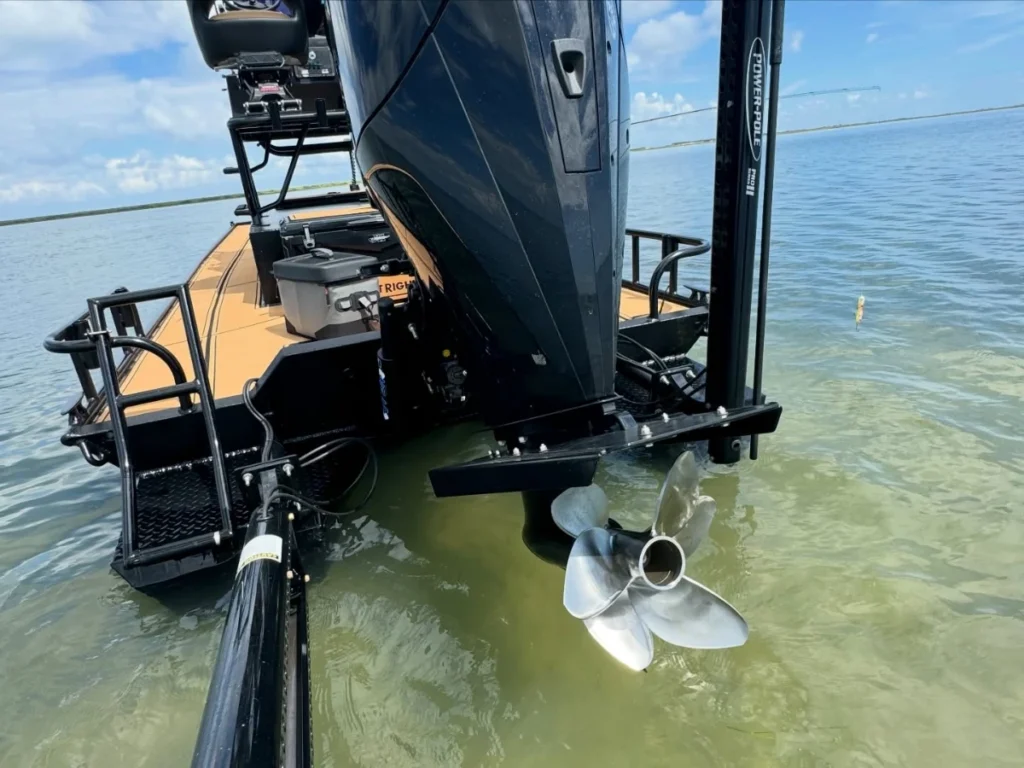 Outboard jacked up with the propeller just under clear shallow water