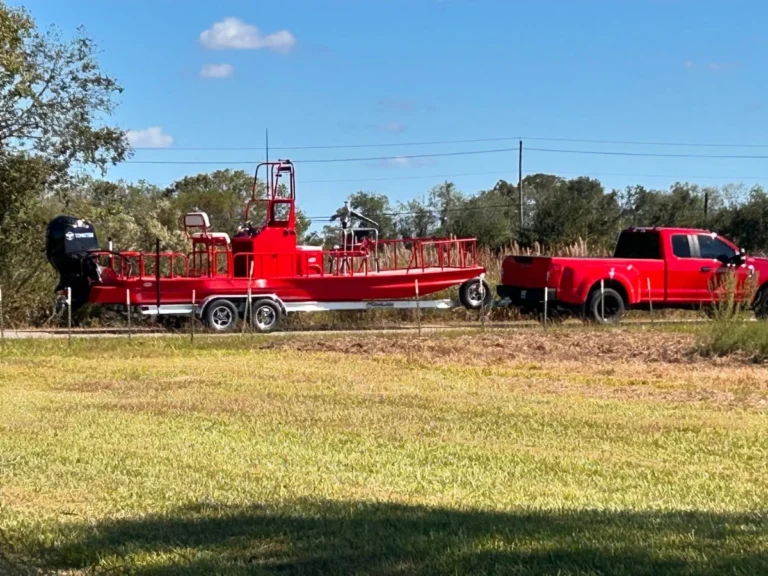 Red Boat Right hitched behind a red pickup truck
