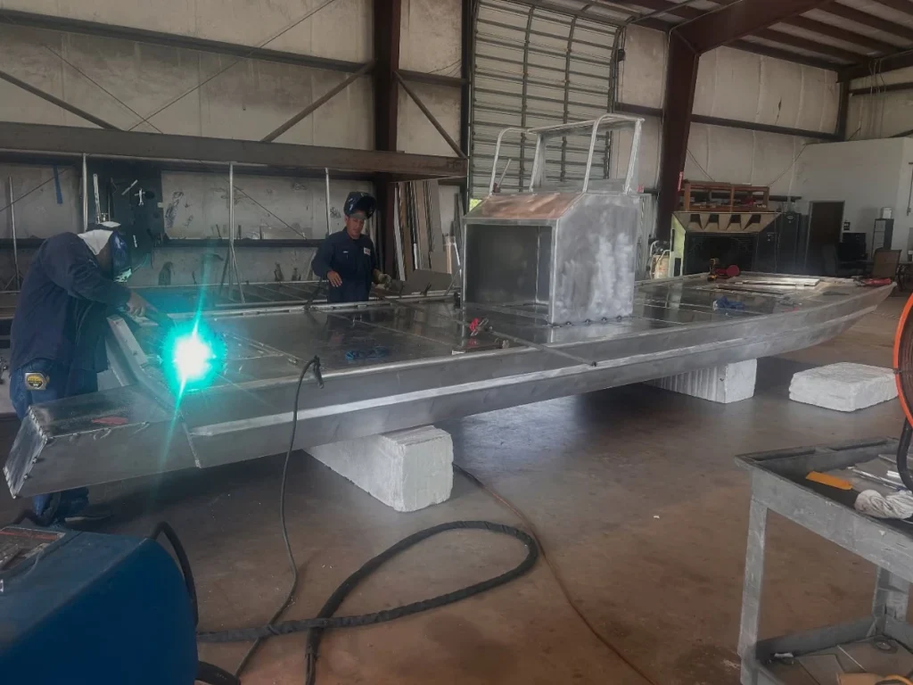 Welder working on an aluminum hull in the Boat Right shop